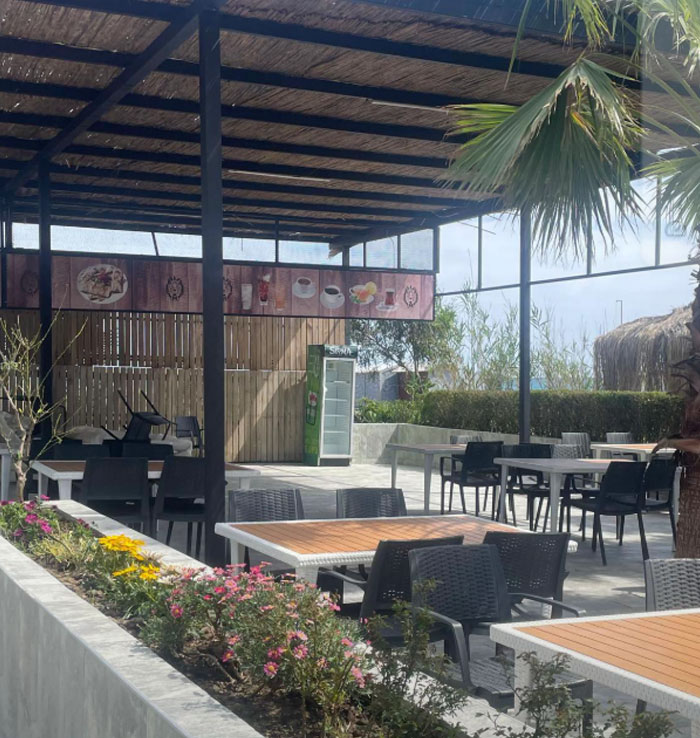 Outdoor dining area at a 5-star resort in Turkey, featuring empty tables and vibrant floral decor. Outdoor dining area at a 5-star resort in Turkey, featuring empty tables and vibrant floral decor.