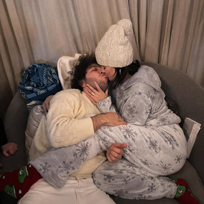 A couple in winter outfits kissing on a couch, highlighting intimate life elements. A couple in winter outfits kissing on a couch, highlighting intimate life elements.