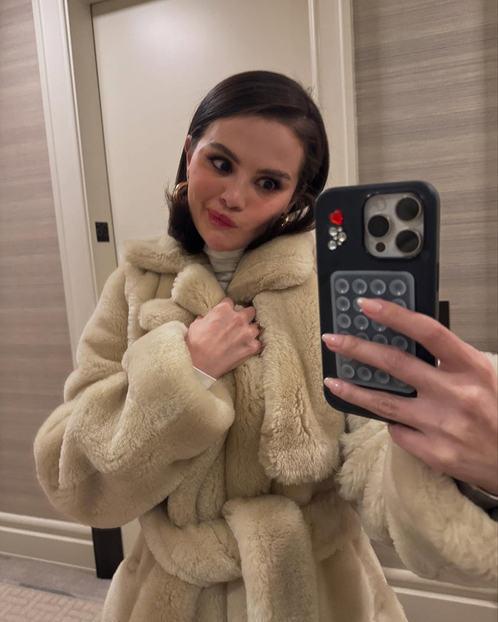 Woman in a fur coat takes a selfie, showcasing peek into intimate life. Woman in a fur coat takes a selfie, showcasing peek into intimate life.