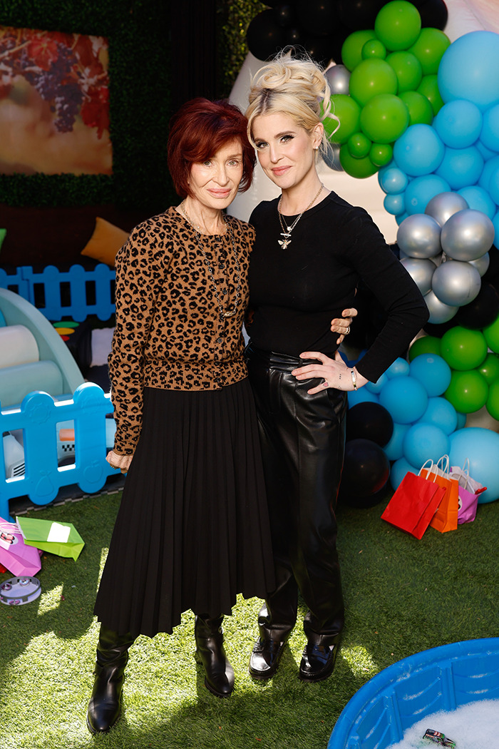 Sharon Osbourne and another person at a colorful outdoor event, standing on grass with balloons in the background. Sharon Osbourne and another person at a colorful outdoor event, standing on grass with balloons in the background.