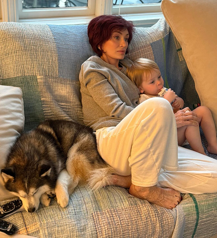 Woman with short red hair, child, and dog on a sofa, illustrating the Ozempic feet discussion. Woman with short red hair, child, and dog on a sofa, illustrating the Ozempic feet discussion.