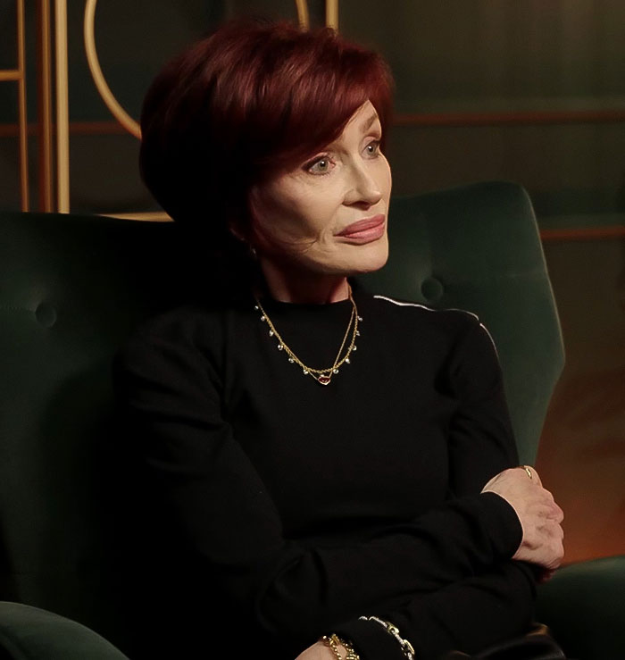 A woman with red hair and black outfit sits in a green chair, relating to Ozempic Feet side effect discussion. A woman with red hair and black outfit sits in a green chair, relating to Ozempic Feet side effect discussion.