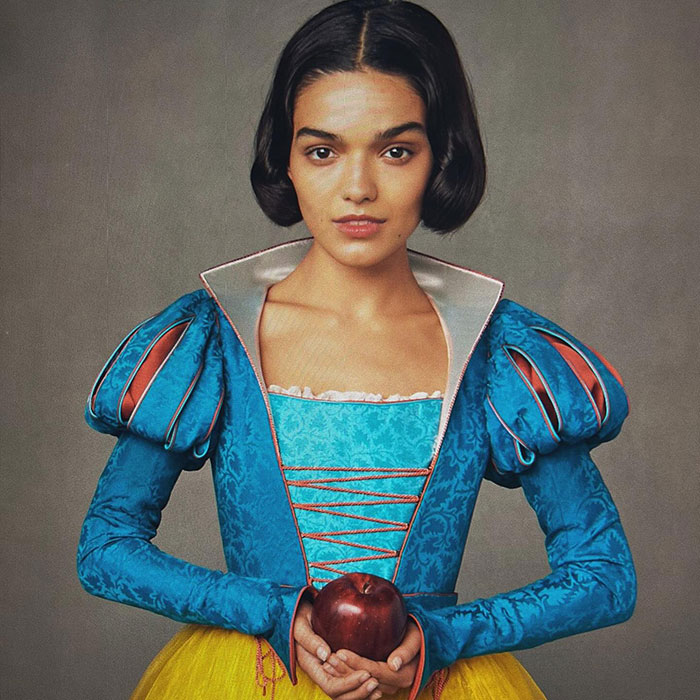 Young woman in a vibrant costume, holding an apple, spotlight on "Rachel Zegler. Young woman in a vibrant costume, holding an apple, spotlight on "Rachel Zegler.