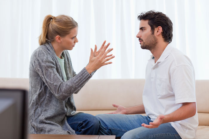 Man and woman having a tense discussion indoors, reflecting conflict about dad catching teen son creeping around neighbor’s yard. Man and woman having a tense discussion indoors, reflecting conflict about dad catching teen son creeping around neighbor’s yard.