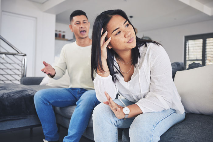 Man and woman having a serious discussion on a sofa, highlighting possible disregard for child allergies. Man and woman having a serious discussion on a sofa, highlighting possible disregard for child allergies.