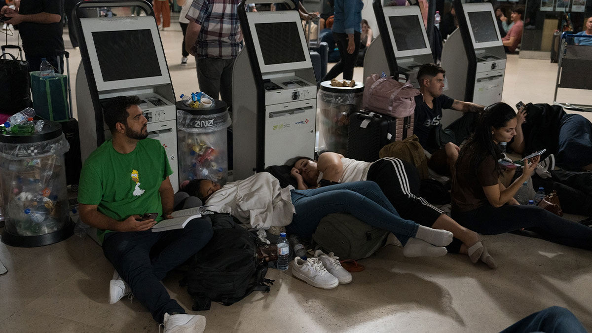 Group of Europeans resting on the floor at a station during a major blackout, with activities and services paralyzed.