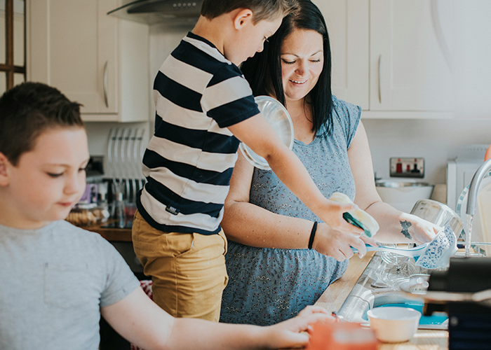 Mother and children in kitchen, doing dishes together, focusing on chores and family teamwork. Mother and children in kitchen, doing dishes together, focusing on chores and family teamwork.