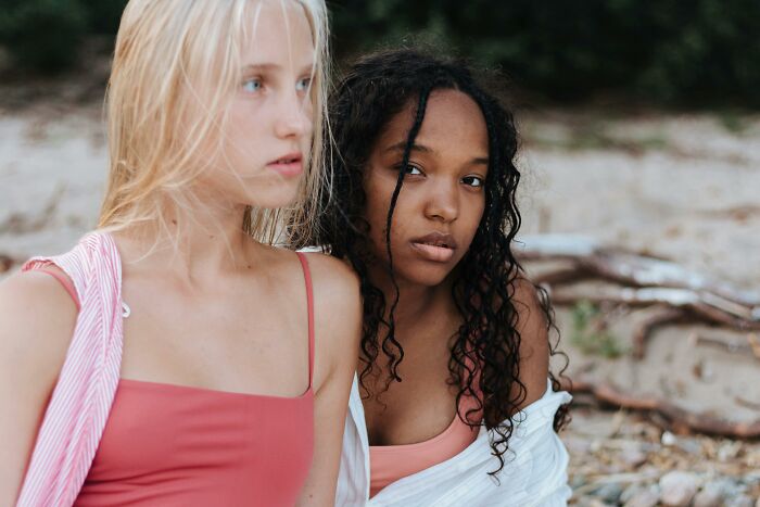 Two young women at a beach during a holiday, showing stepdaughter and stepmom tension and drama. Two young women at a beach during a holiday, showing stepdaughter and stepmom tension and drama.