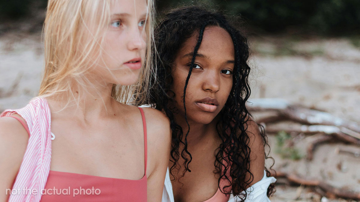 Two young women at the beach showing subtle tension and emotion, capturing stepdaughter holiday stepmom drama vibes.