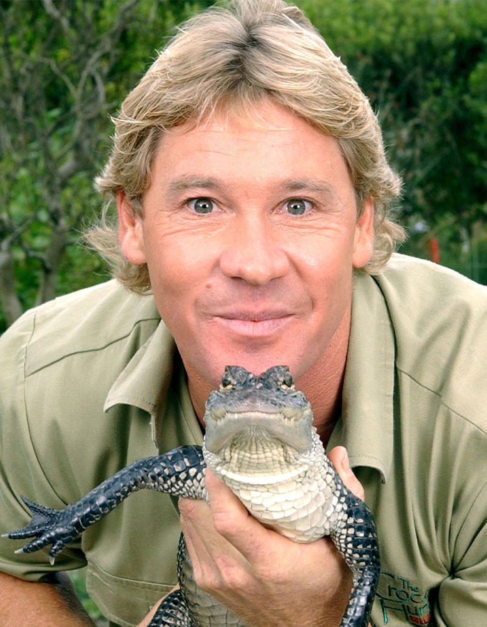 Steve Irwin holding a small crocodile and smiling, wearing a khaki shirt, in an outdoor setting. Steve Irwin holding a small crocodile and smiling, wearing a khaki shirt, in an outdoor setting.