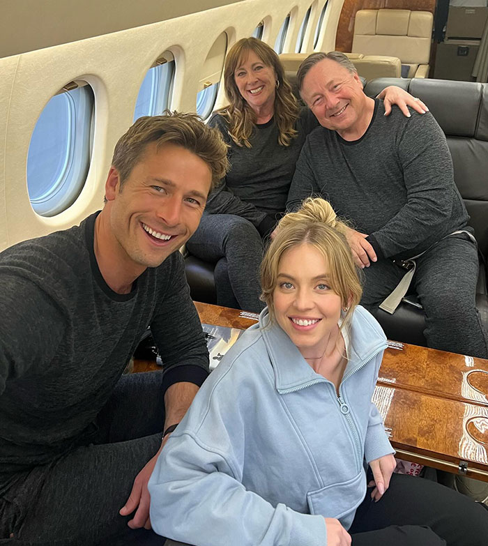 Sydney Sweeney with friends on a plane, causing fan debate about her outfit choice. Sydney Sweeney with friends on a plane, causing fan debate about her outfit choice.