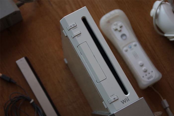 Nintendo Wii console with remote and cables on a wooden table, highlighting fun facts about gaming devices.