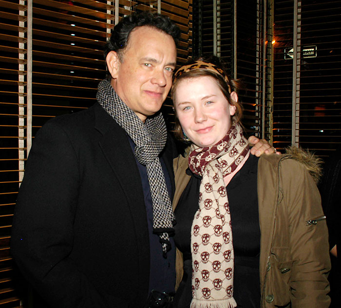 Father and daughter smiling together, dressed warmly with scarves, indoors. Father and daughter smiling together, dressed warmly with scarves, indoors.