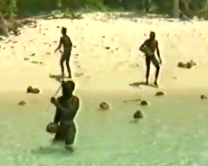 Tribe members on a beach, highlighting isolation and risk from YouTuber's Diet Coke stunt. Tribe members on a beach, highlighting isolation and risk from YouTuber's Diet Coke stunt.