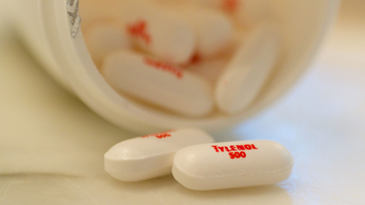 White Tylenol 500 pills spilling out of a bottle, representing moments in history with important medical impact.