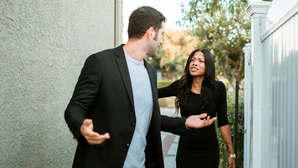 Couple arguing outdoors with tense expressions, illustrating things peopleu2019s exes did that still make blood boil.