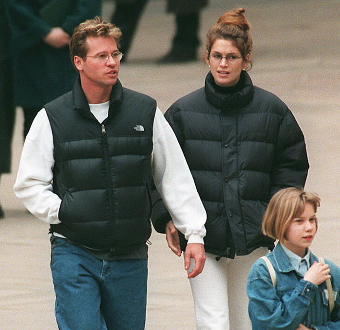 Man in casual attire walking with two women, wearing winter coats, in an urban setting. Man in casual attire walking with two women, wearing winter coats, in an urban setting.