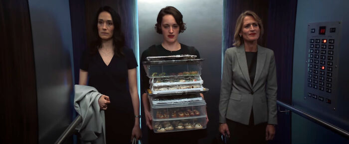 Three women in an elevator, one holding food trays, related to a top-rated TV show discussion.