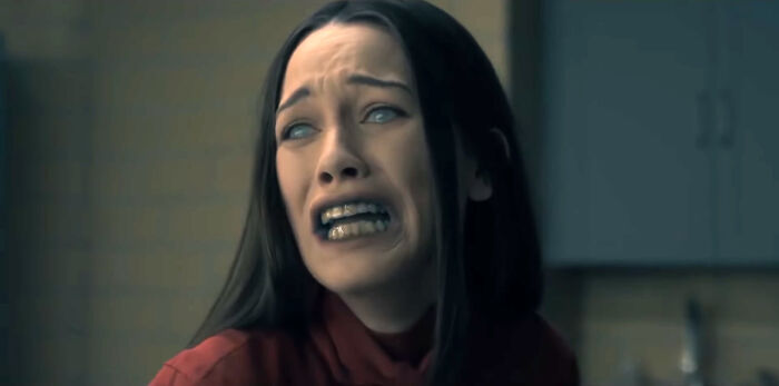 A woman with long hair in a distressed scene from a TV show, expressing intense emotion.