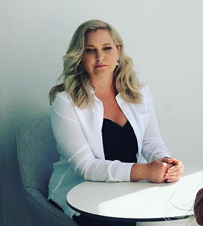 Woman with blonde hair, wearing a white shirt over black top, sitting at a round table, discussing Virginia Giuffre lawyer claim doubt. Woman with blonde hair, wearing a white shirt over black top, sitting at a round table, discussing Virginia Giuffre lawyer claim doubt.