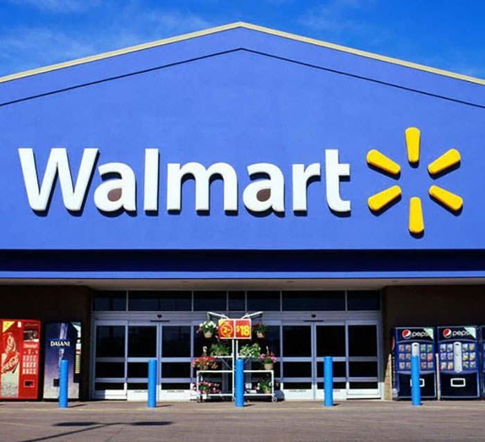 Walmart store exterior with bright signage on a sunny day. Walmart store exterior with bright signage on a sunny day.