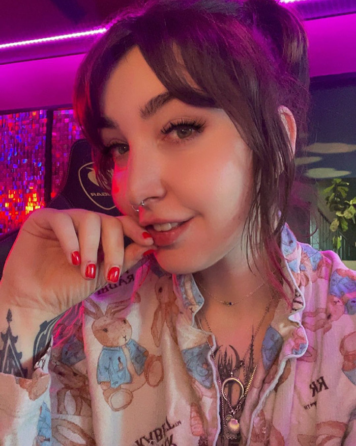 Woman with brown hair and nose piercing in a colorful room, related to charging controversy based on pubic area size. Woman with brown hair and nose piercing in a colorful room, related to charging controversy based on pubic area size.