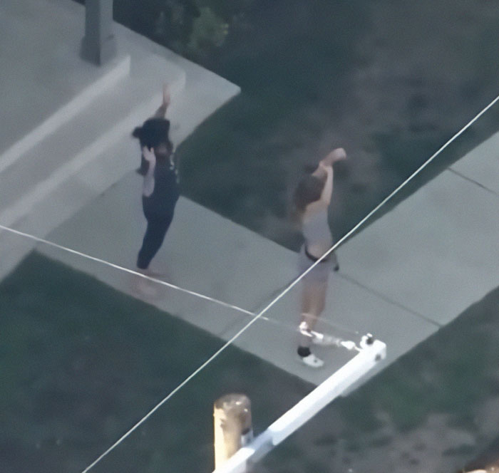 Two people with hands raised during police search related to hit-and-run in LA. Two people with hands raised during police search related to hit-and-run in LA.