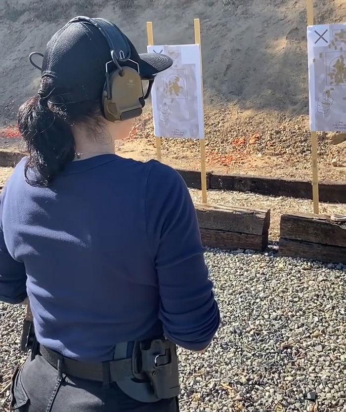 Officer at shooting range during manhunt in LA, wearing a tactical headset and observing targets. Officer at shooting range during manhunt in LA, wearing a tactical headset and observing targets.