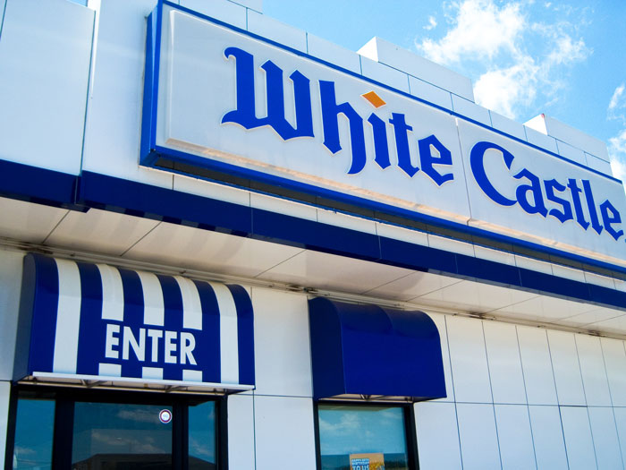 White Castle restaurant exterior with entrance sign under blue sky.