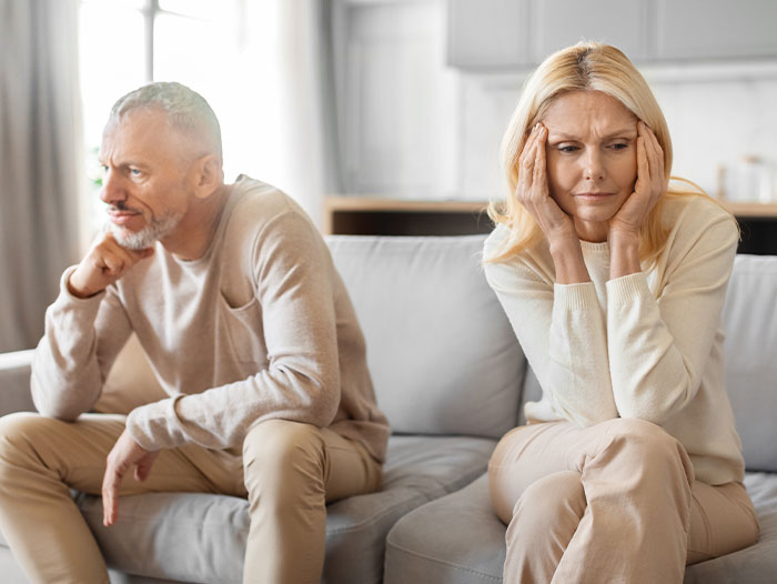 Couple on sofa, woman worried, reflecting on secret name change. Couple on sofa, woman worried, reflecting on secret name change.