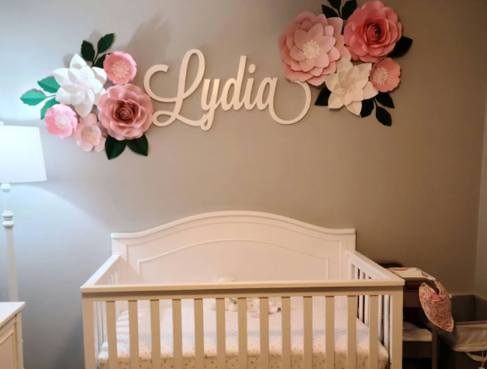 Nursery with floral decor and crib under the name Lydia, reflecting a personal name change theme. Nursery with floral decor and crib under the name Lydia, reflecting a personal name change theme.