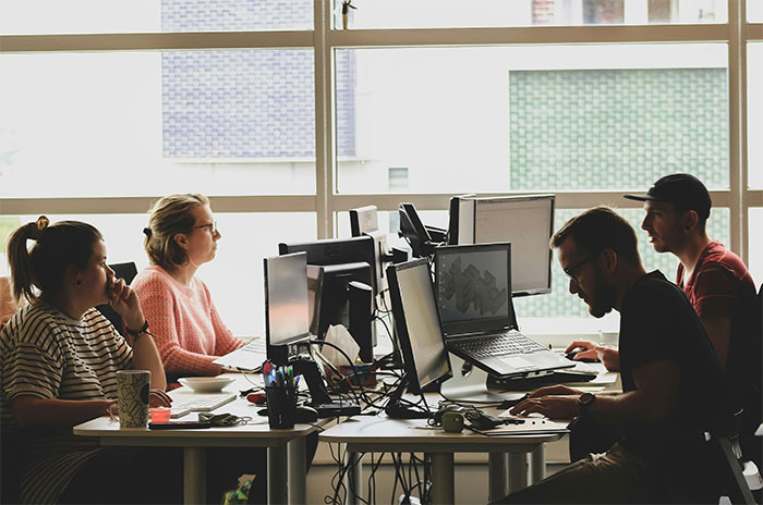 Office workers focused on computer screens in a modern workspace illustrating attention seeking in a professional setting. Office workers focused on computer screens in a modern workspace illustrating attention seeking in a professional setting.