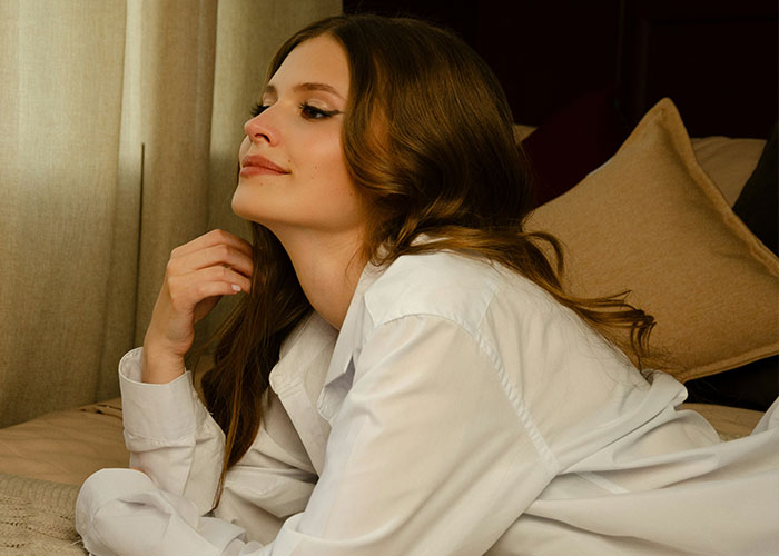 Woman in a white shirt looking thoughtful, reflecting on an emotional moment with her husband’s childhood best friend. Woman in a white shirt looking thoughtful, reflecting on an emotional moment with her husband’s childhood best friend.