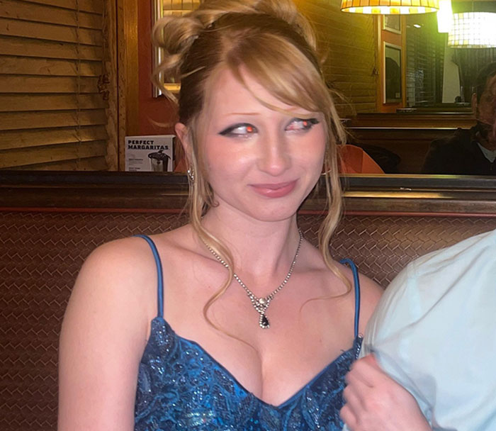 Teen girl in a blue dress and necklace at a restaurant, related to expulsion from Christian school over trans prom date debate. Teen girl in a blue dress and necklace at a restaurant, related to expulsion from Christian school over trans prom date debate.