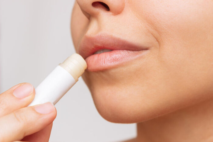 Close-up of a person applying lip balm, highlighting a tiny thing that made the trip better for lip care.