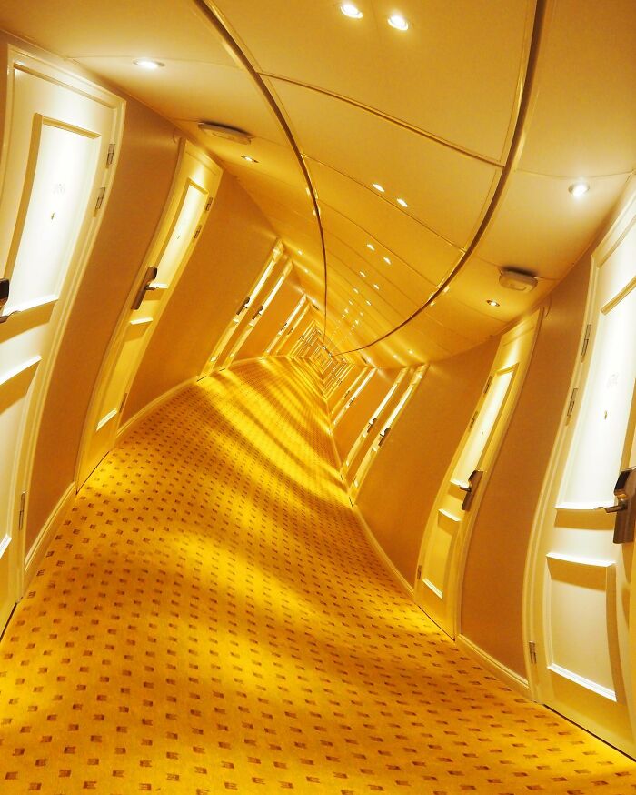 Surreal hallway with warped walls and doors, showcasing creative photo manipulations that invite us to a surreal reality.