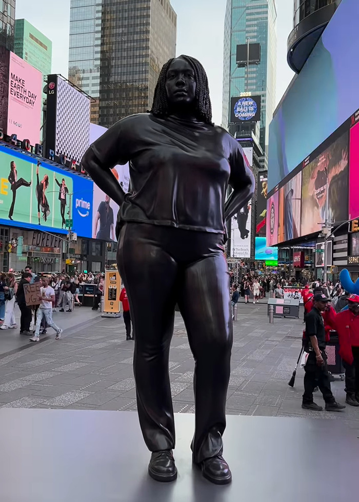 Statue of black woman in NYC Times Square stands tall amidst busy urban backdrop, sparking public debate. Statue of black woman in NYC Times Square stands tall amidst busy urban backdrop, sparking public debate.