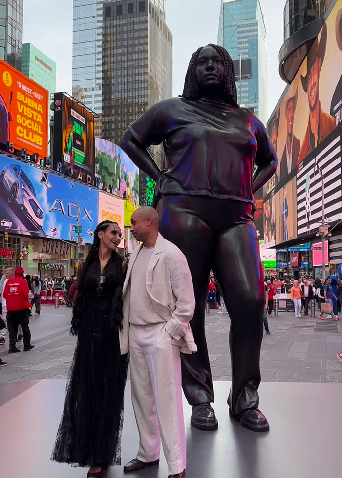Statue of Black woman in NYC Times Square with people nearby amid urban billboards and crowds. Statue of Black woman in NYC Times Square with people nearby amid urban billboards and crowds.