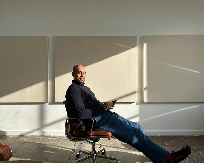 Man sitting on office chair in minimalist room, sunlight casting shadows, related to statue of black woman debate in NYC. Man sitting on office chair in minimalist room, sunlight casting shadows, related to statue of black woman debate in NYC.
