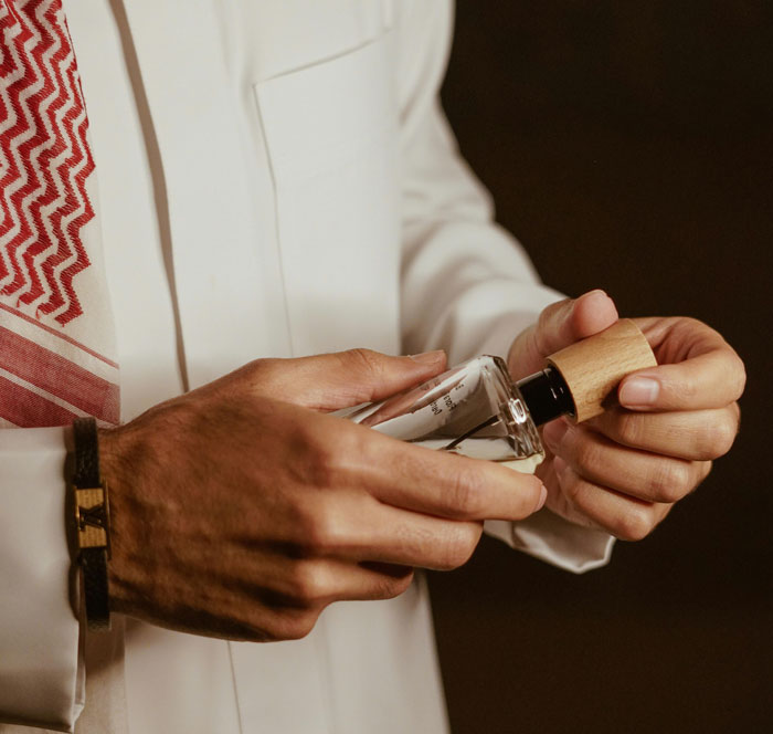 Man in traditional clothing holding a glass perfume bottle symbolizing secrets spouses keep after marriage