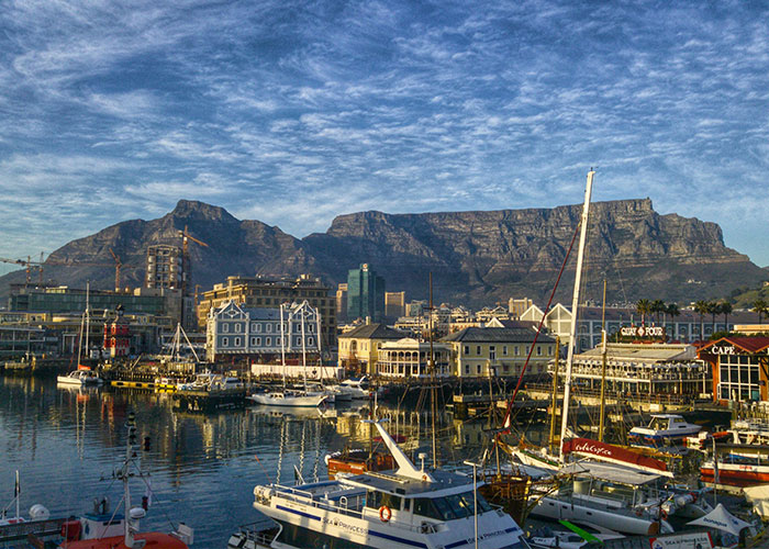 Scenic harbor with boats and waterfront buildings showcasing the best and worst things about living in home countries.