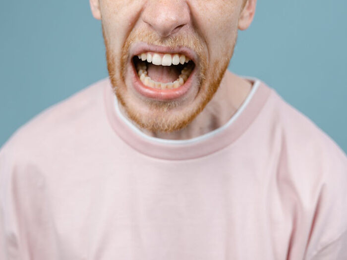 Close-up of a red-haired man shouting with mouth open, illustrating national stereotypes in a humorous context.