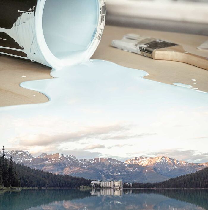 Photo manipulation showing white paint pouring from a can blending into a mountain lake landscape with brushes nearby.