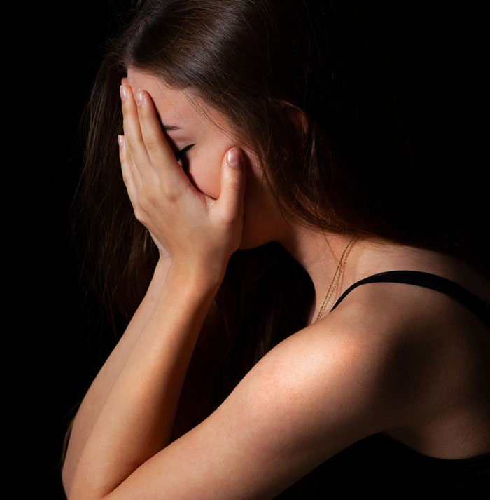 Woman covering her face with hands, expressing emotion and vulnerability about secrets kept by spouse after marriage
