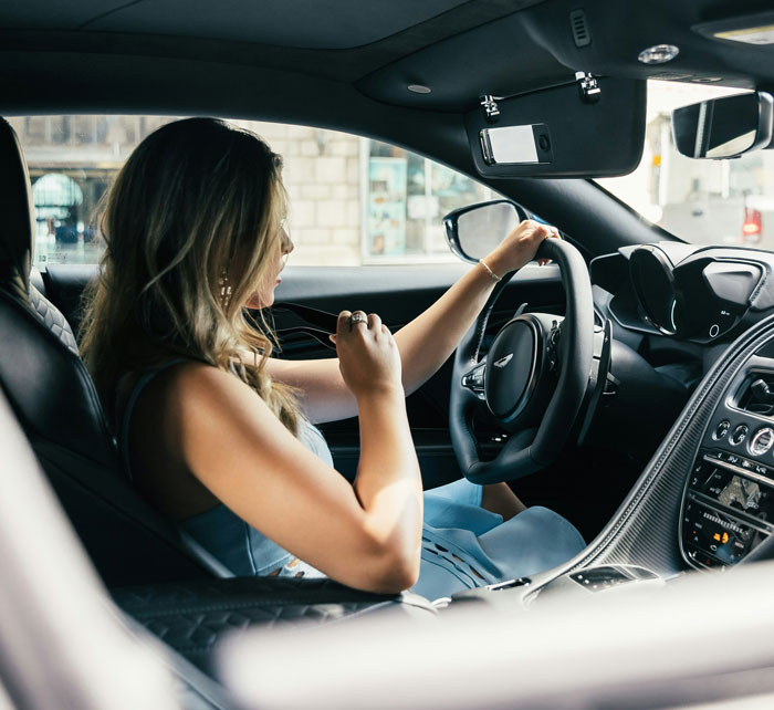 Woman driving a luxury car, illustrating common money saving mistakes that actually end up costing more over time.
