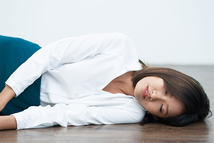Young woman lying on office floor appearing unconscious in a severe case of attention seeking situation. Young woman lying on office floor appearing unconscious in a severe case of attention seeking situation.