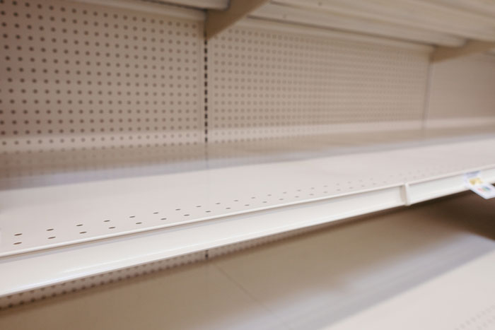 Empty store shelves with no products, illustrating effects of manager decisions on staff and sales performance. Empty store shelves with no products, illustrating effects of manager decisions on staff and sales performance.