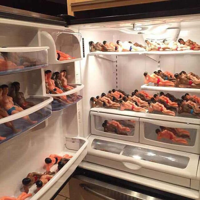 Multiple small male figurines arranged inside a refrigerator, creating a bizarre and cursed images scene.