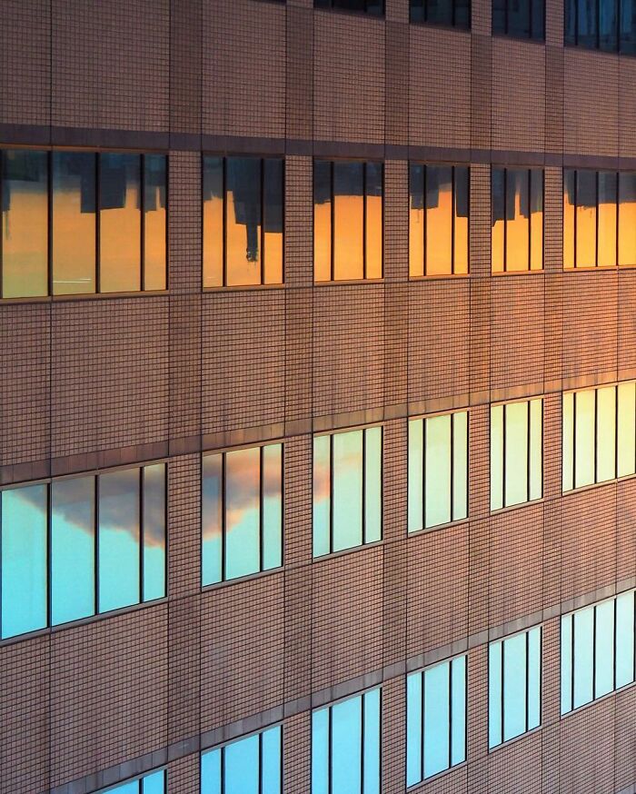 Reflection of cityscape and sky on building windows creating creative photo manipulations with surreal reality effect.