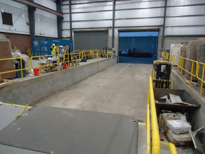 Industrial warehouse interior with loading dock and yellow safety railings, illustrating challenges faced by people in charge.